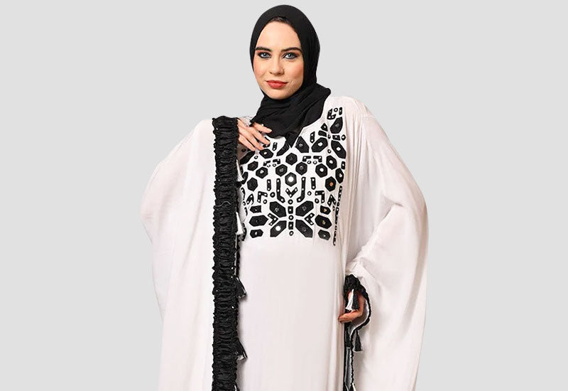 women wearing butterfly style light color abaya with black embroidery